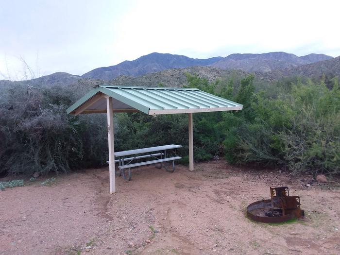 Campsite 13 at Burnt Corral Campground with a picnic table, fire ring, shade structure, and parking.