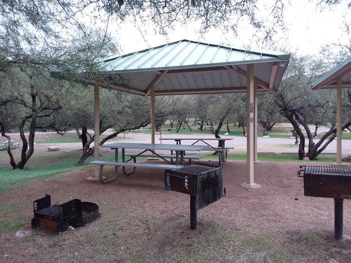 Site 31C with picnic tables, a fire ring, camp grill, a shade structure, and parking.