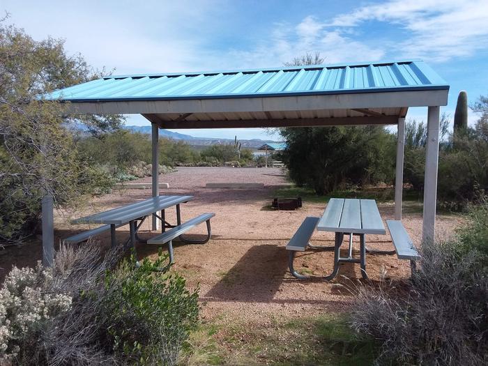 Site 14 with picnic tables, a fire ring, shade structure, and parking.