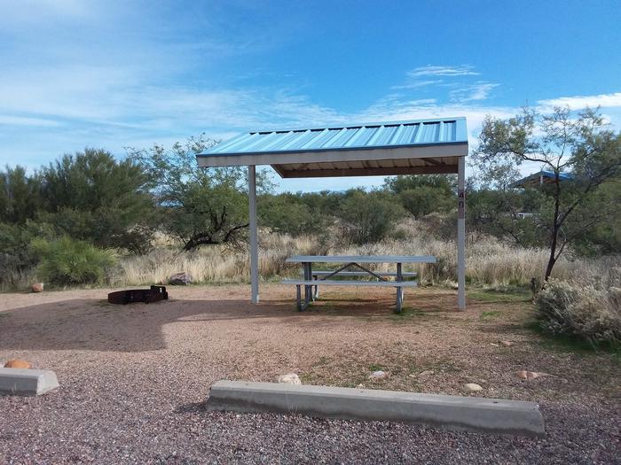Site 40 with a picnic table, fire ring, shade structure, and parking.