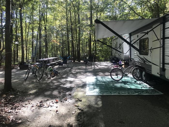 A photo of Site A020 of Loop A at TWIN KNOBS CAMPGROUND with Picnic Table, Electricity Hookup, Fire Pit, Shade, Tent Pad, Full Hookup