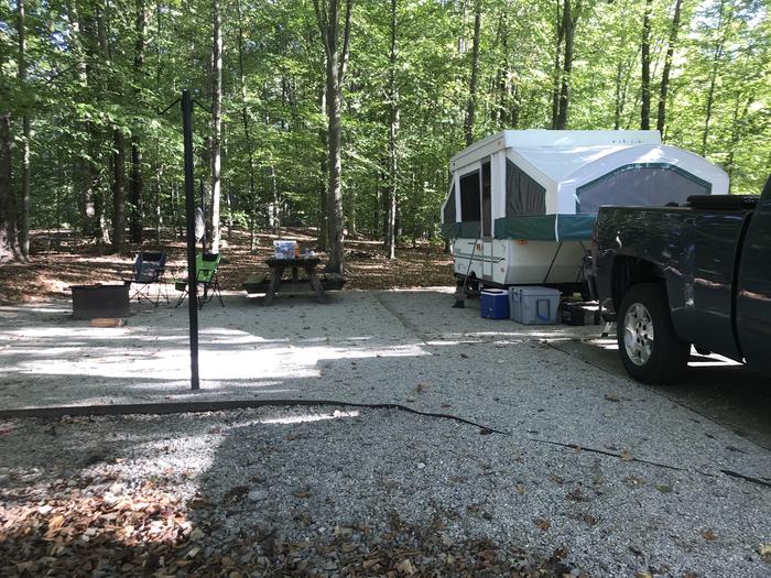 A photo of Site F021 of Loop F at TWIN KNOBS CAMPGROUND with Picnic Table, Fire Pit, Shade, Tent Pad, Lantern Pole