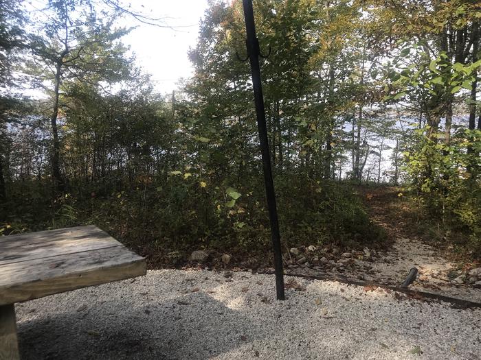 A photo of Site F020 of Loop F at TWIN KNOBS CAMPGROUND with Picnic Table, Fire Pit, Shade, Tent Pad, Waterfront, Lantern Pole