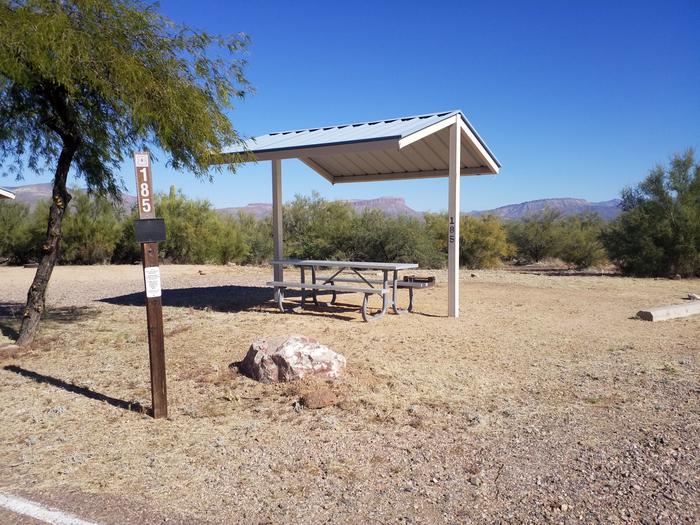 Campsite 185 at SchoolhouseSite 185 with a picnic table, a fire ring, shade structure, and parking.