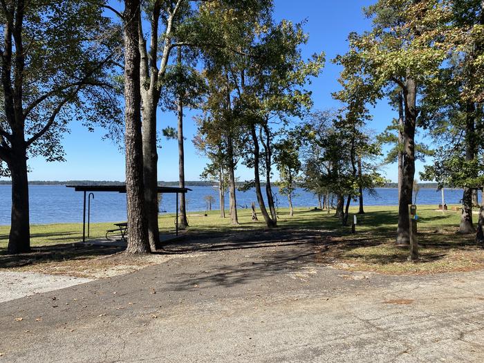 A photo of Site 032 of Loop E at MILL CREEK (TEXAS) with Picnic Table, Electricity Hookup, Fire Pit, Shade, Waterfront, Lantern Pole, Water Hookup