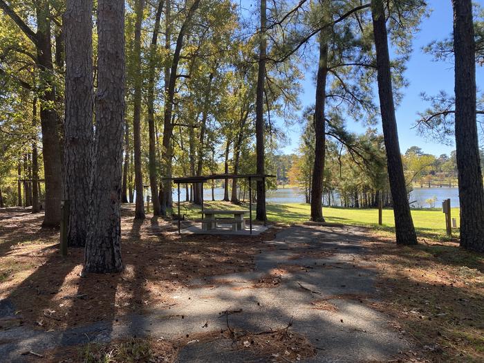 A photo of Site 098 of Loop D at MILL CREEK (TEXAS) with Picnic Table, Electricity Hookup, Fire Pit, Shade, Waterfront, Lantern Pole, Water Hookup
