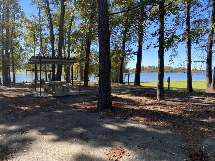 A photo of Site 101 of Loop D at MILL CREEK (TEXAS) with Picnic Table, Electricity Hookup, Fire Pit, Shade, Waterfront, Lantern Pole, Water Hookup