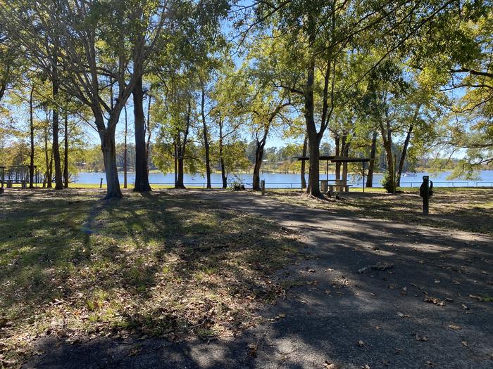 A photo of Site 090 of Loop D at MILL CREEK (TEXAS) with Picnic Table, Electricity Hookup, Fire Pit, Shade, Waterfront, Lantern Pole, Water Hookup