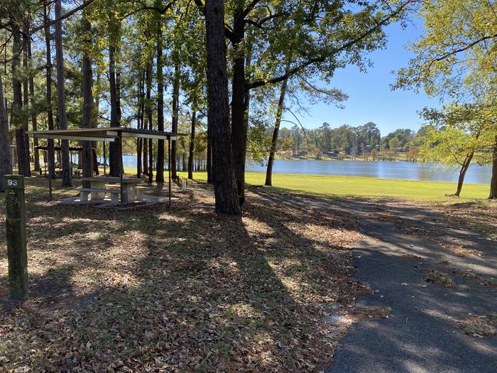 A photo of Site 093 of Loop D at MILL CREEK (TEXAS) with Picnic Table, Electricity Hookup, Fire Pit, Shade, Waterfront, Lantern Pole, Water Hookup