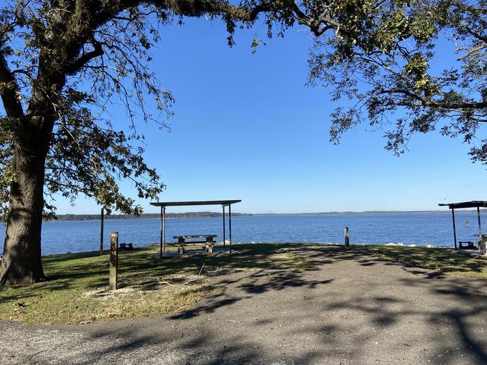 A photo of Site 074 of Loop C at MILL CREEK (TEXAS) with Boat Ramp, Picnic Table, Fire Pit, Shade, Waterfront, Lantern Pole, Water Hookup