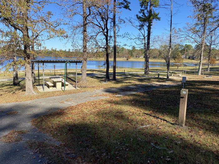 A photo of Site 19 of Loop LOOA at SAN AUGUSTINE with Picnic Table, Electricity Hookup, Fire Pit, Shade, Waterfront, Lantern Pole, Water Hookup, Lean To / Shelter