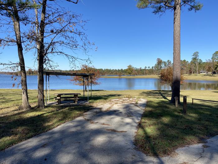 A photo of Site 11 of Loop LOOA at SAN AUGUSTINE with Picnic Table, Electricity Hookup, Fire Pit, Shade, Waterfront, Lantern Pole, Water Hookup, Lean To / Shelter