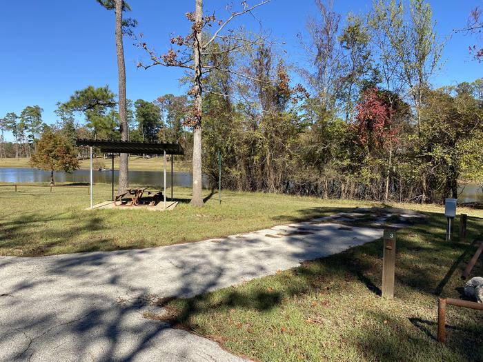 A photo of Site 03 of Loop LOOA at SAN AUGUSTINE with Picnic Table, Electricity Hookup, Fire Pit, Shade, Waterfront, Lantern Pole, Water Hookup, Lean To / Shelter