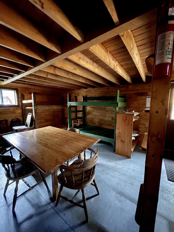 Bunks, table and chairs inside Big Spring Brook Hut.Big Spring Brook Hut offers bunks and a kitchen area to accommodate groups.