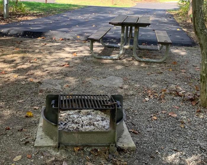 A gravel area with a circle fire ring and picnic table.B-7 has a fire ring and picnic table.