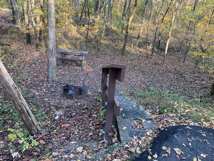 Brown railing with stairs leading to a grassy area with a circle fire ring and picnic table.C-22 has a fire ring and picnic table.
