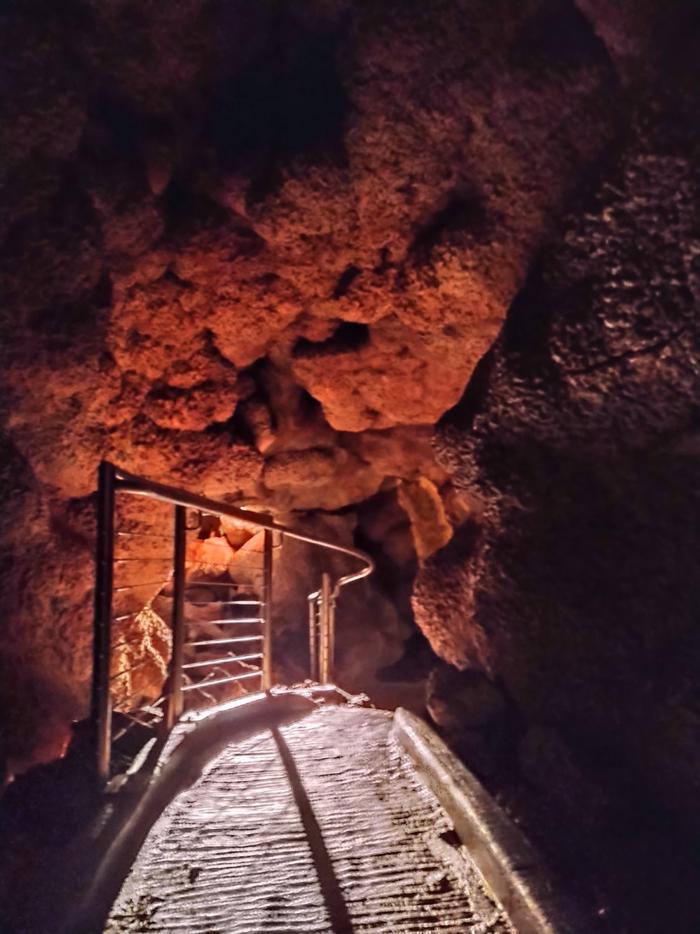 Illuminated path in a cave passage.Be sure to watch your step and your head! Some stooping is required on the Scenic Tour.
