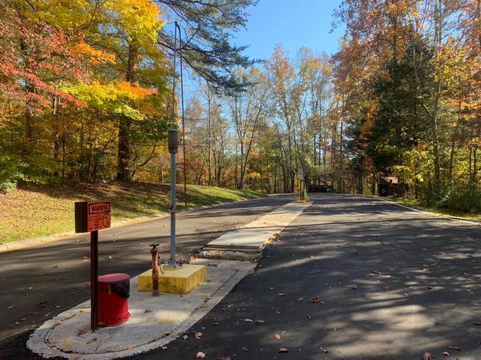 A blacktop road with red and yellow cables to the left.Dump Station available for campers. 
