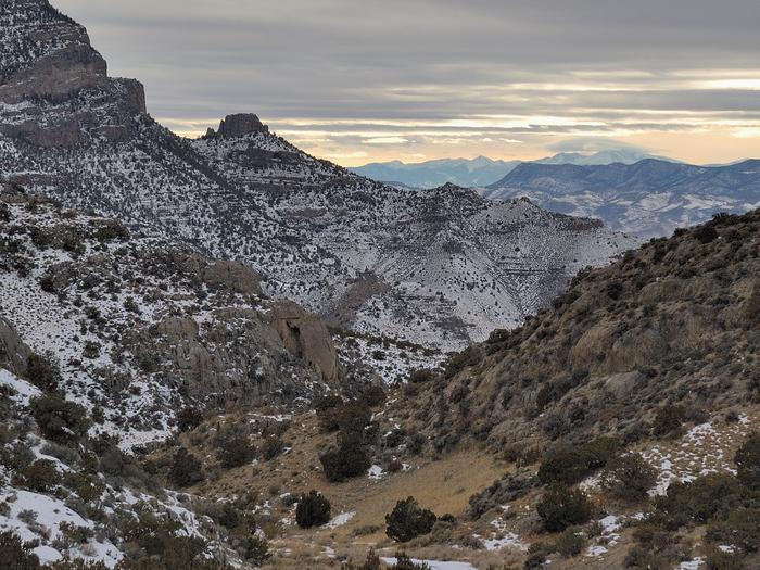 Canyon with a dusting of snow. Tall snowy peaks in the distance.Early winter in the Great Basin