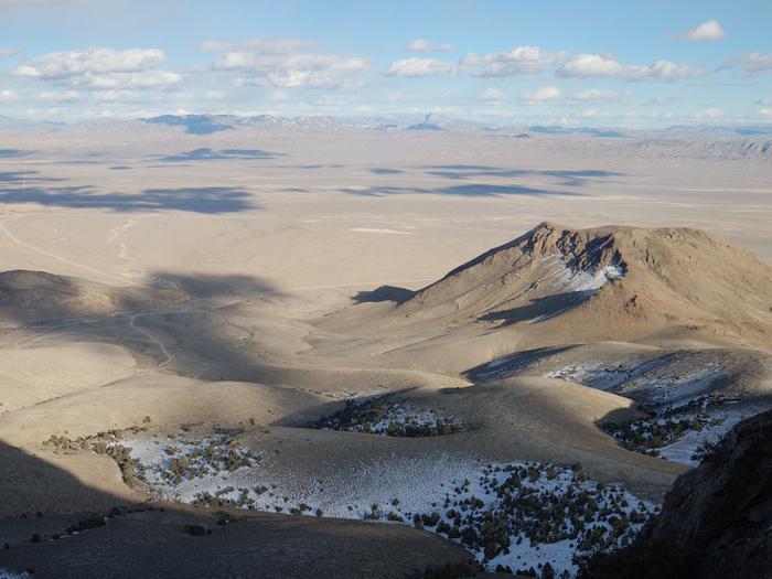 Long view of open desert with mountains and cloud shadowsThe Great Basin has great light