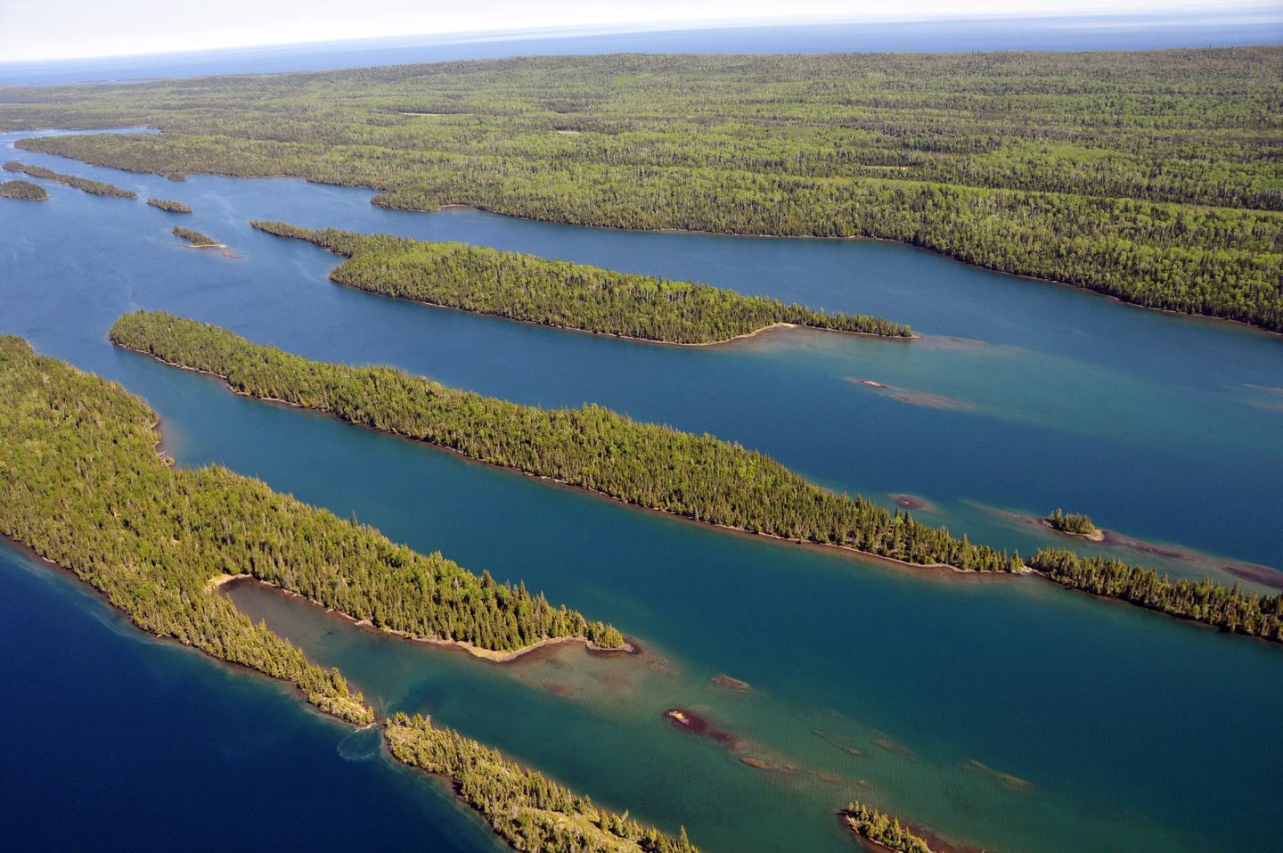 Aerial View of Belle HarborIsle Royale is also called Minong, which means "the good place" by the Grand Portage Band of Lake Superior Chippewa. Minong is a part of the ancestral lands of the Anishinaabe/Ojibwe peoples who have cared for these lands from time immemorial.