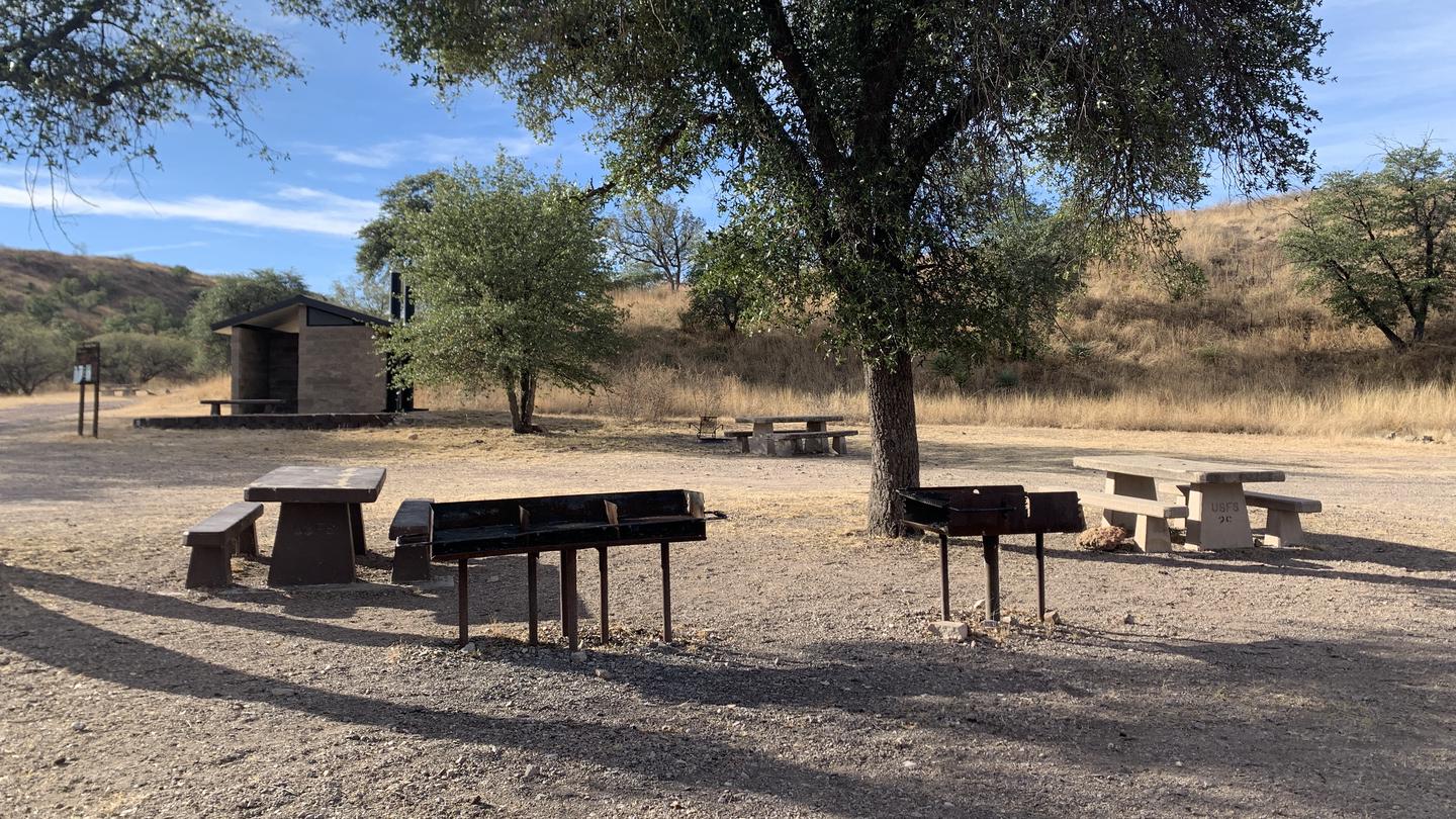 Picnic tables, grills and a pit toilet at the central area of the Calabasas campground.The central area of the Calabasas campground! Up to 250 people can stay here, with lots of open space to car and tent camp, conduct trainings, or host family reunions!