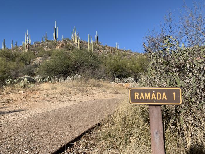 Paved path to the left of a sign saying "Ramada 1"Paved paths make both Cactus Ramada 1 and 2 wheelchair and handicap accessible.