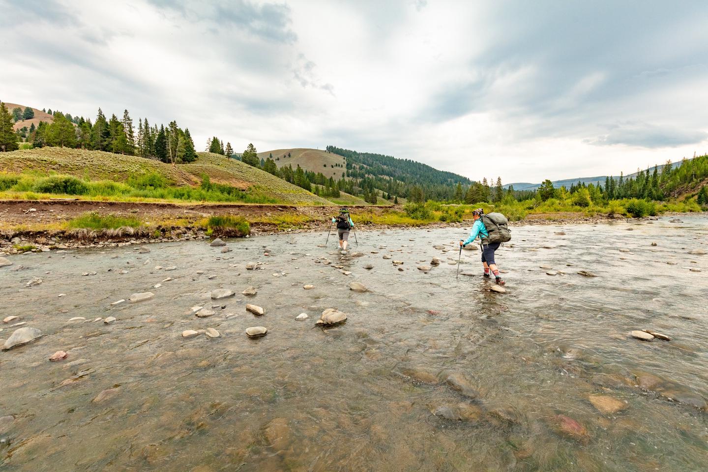 Two backpackers crossing a creekCrossing Cache Creek in late summer