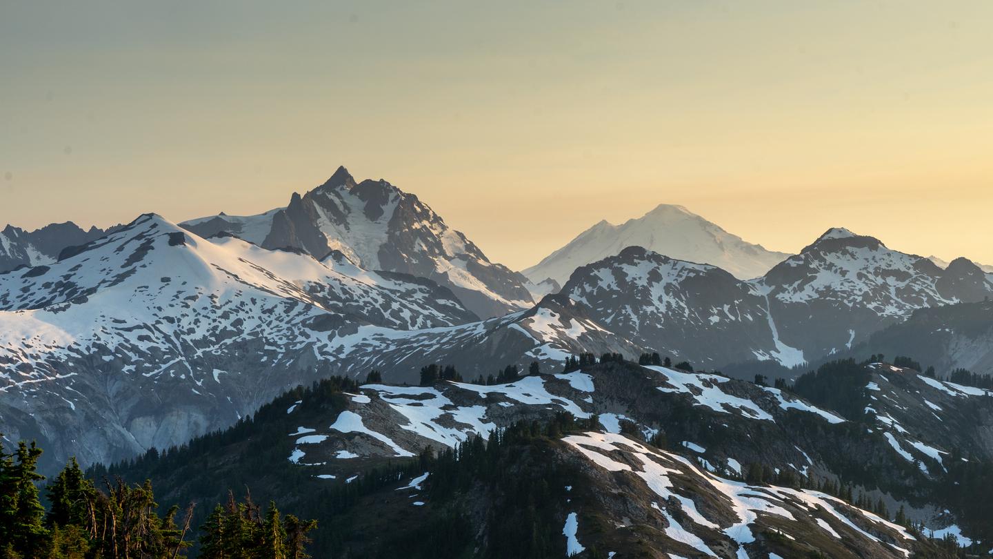 A view of jagged peaks covered with snow.View of Mt. Shuksan and Mt. Baker from Copper Ridge.