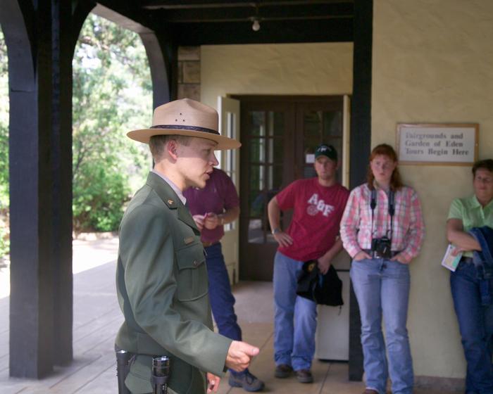 A ranger stands in the foreground talks to a group of visitors.All cave access is by guided tour.