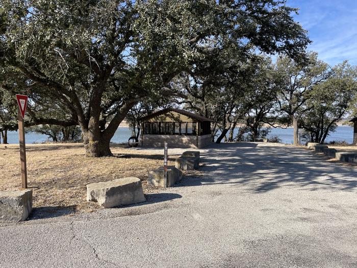 A photo of Site T013 of Loop L1 at LAKESIDE (TX) with Picnic Table, Electricity Hookup, Fire Pit, Shade, Waterfront, Water Hookup, Lean To / Shelter