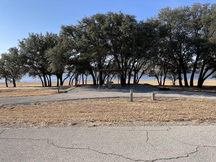 A photo of Site T006 of Loop L1 at LAKESIDE (TX) with Picnic Table, Electricity Hookup, Fire Pit, Shade, Waterfront, Water Hookup