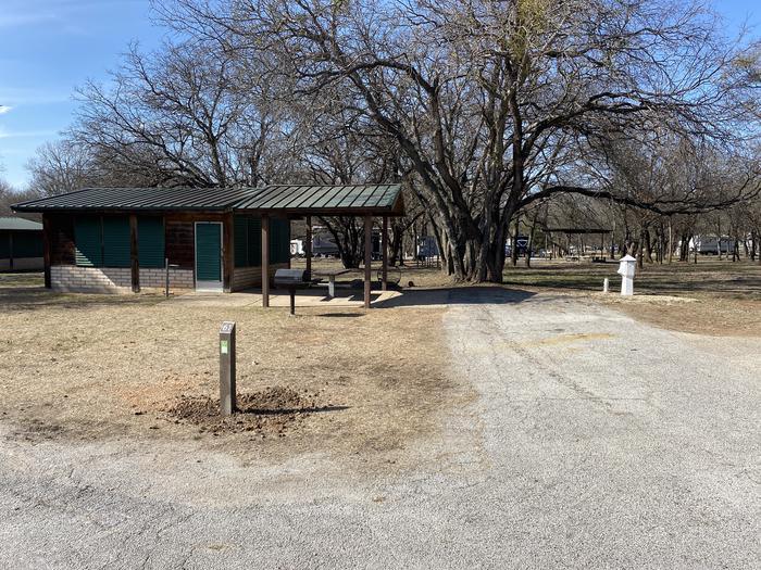 A photo of Site 061 of Loop SOUT at Holiday (Texas) with Picnic Table, Electricity Hookup, Fire Pit, Shade, Water Hookup, Lean To / Shelter