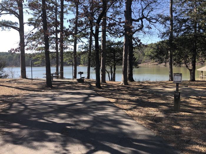 A photo of Site 053 of Loop NORTH SHORE at CEDAR LAKE (OKLAHOMA) with Boat Ramp, Picnic Table, Fire Pit, Shade, Tent Pad, Waterfront, Lantern Pole