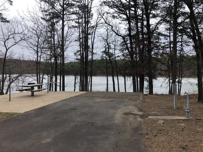 A photo of Site 030 of Loop SANDY BEACH at CEDAR LAKE (OKLAHOMA) with Picnic Table, Electricity Hookup, Fire Pit, Shade, Tent Pad, Waterfront, Lantern Pole, Water Hookup