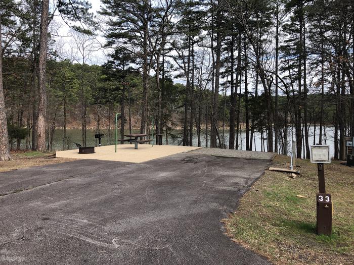 A photo of Site 033 of Loop SANDY BEACH at CEDAR LAKE (OKLAHOMA) with Picnic Table, Electricity Hookup, Fire Pit, Shade, Waterfront, Lantern Pole, Water Hookup