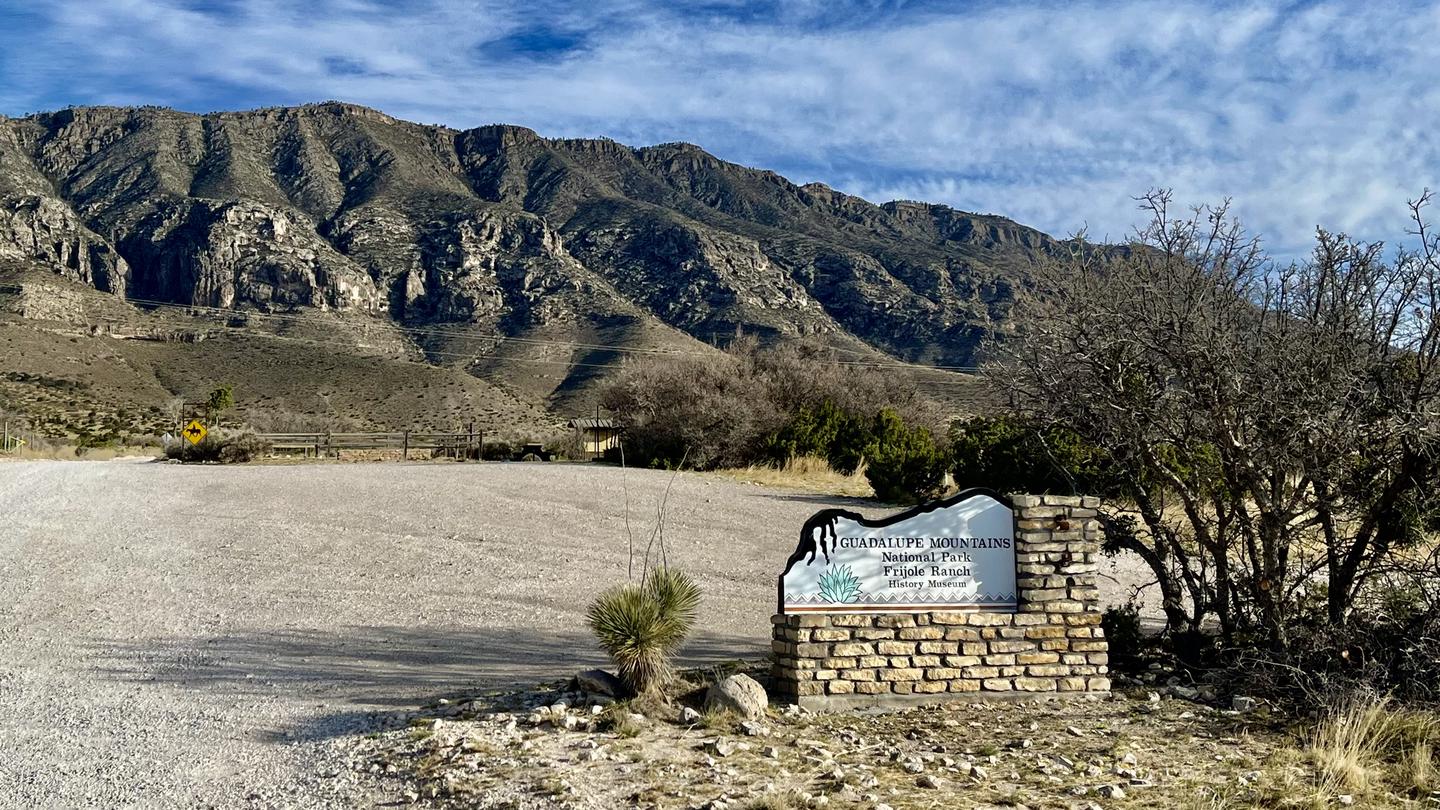Entry sign to the Frijole Ranch area with view of the mountains in the background and the Frijole Horse Corral campground.Entry sign to the Frijole Ranch area of Guadalupe Mountains National Park.