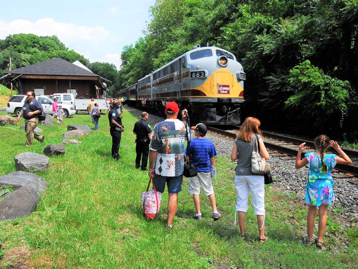People are taking pictures of a train at the station.Delaware Water Gap Train Station