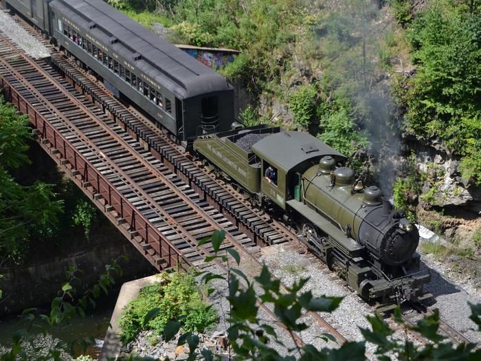 Aerial view of Baldwin Locomotive Works steam locomotive No. 26 crossing bridge in Nay Aug parkExperience the sound of the "chuff chuff" coming from the smokestack of an historic steam locomotive on some of Steamtown's seasonal train rides.