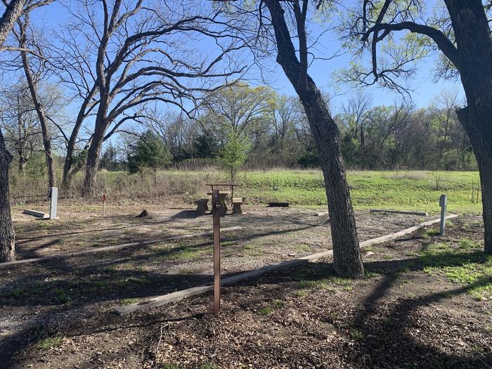 A photo of Site 6 of Loop A at Damsite Texas with Picnic Table, Electricity Hookup, Fire Pit, Shade, Water Hookup