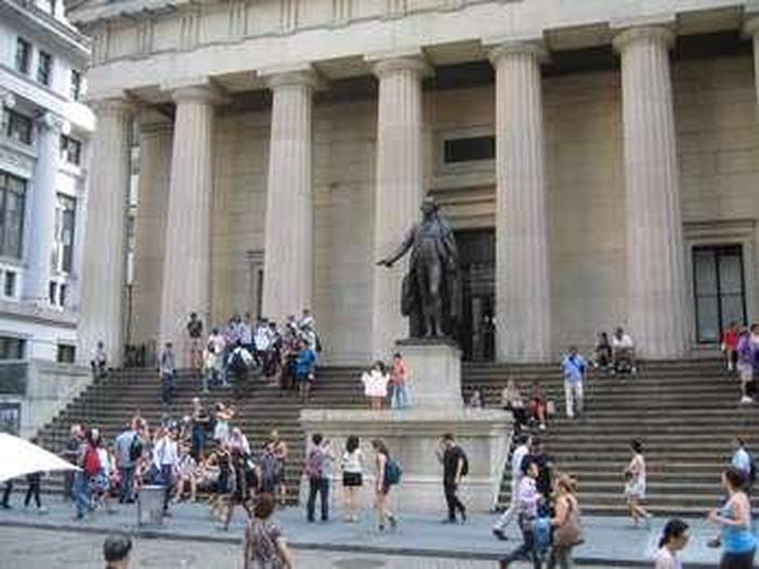 This is a colored photo of the statue of George Washington on the steps of Federal Hall.This statue of George Washington was sculptured by John Quincy Adam Ward. It was erected on the steps of Federal Hall in 1883.