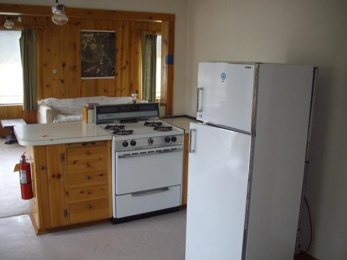 Kitched with white refridgerator and stove and wooden cabinets.Burgdorf Cain - Kitchen