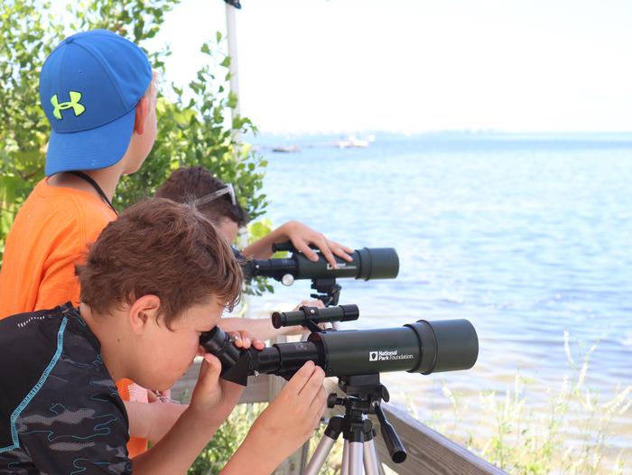Kids looking through telescopes at the Manatee River