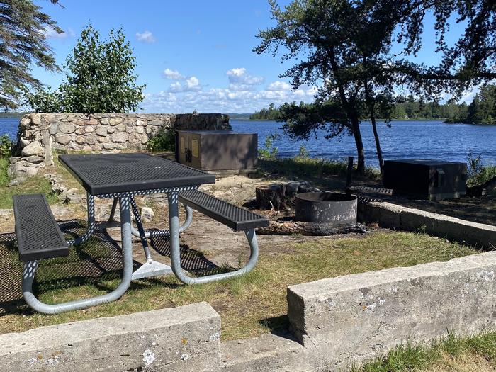 R47 - Whites Point, view of campsite on old cabin foundation with picnic table, fire ring, and bear box.R47 - Whites Point campsite on Rainy Lake