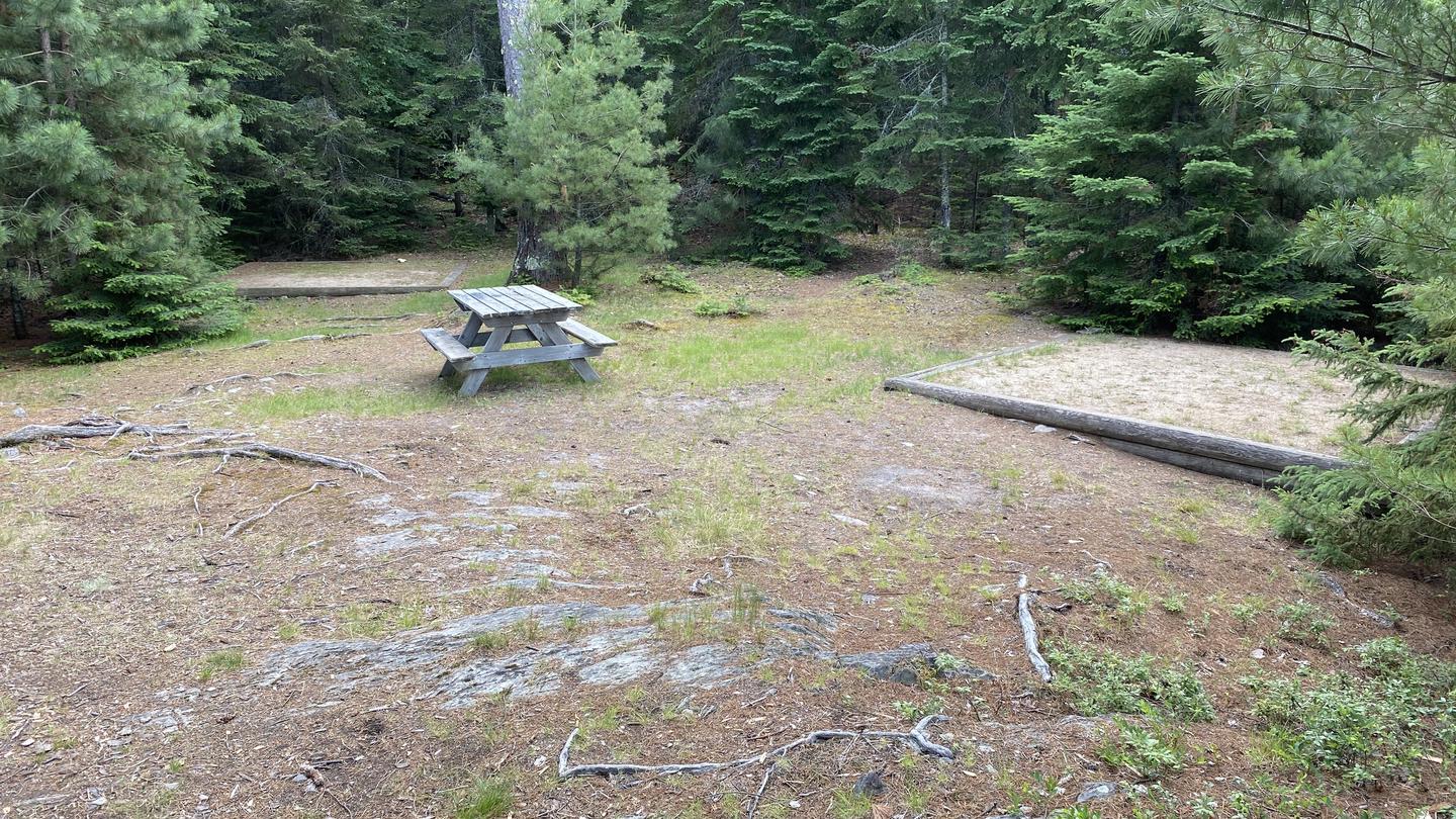 R72 - Rock Shelf, view looking into campsite of a couple tent pads and a picnic table.View of campsite