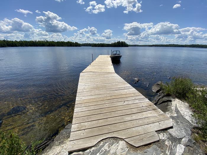 R92 - Blueberry Island West, view of boat dock from shore with a boat tied to the dock.View looking out from boat access