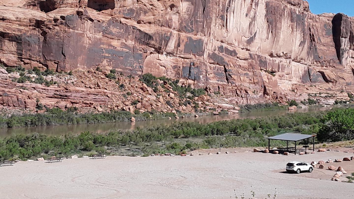 Broad view of Colorado River Day Use Area with red rock cliffs and shade structure.Colorado River Day Use Area with red rock cliffs