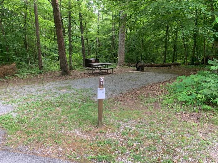 A gravel area with a brown post.D-4 camping space.

