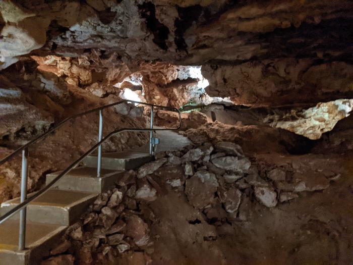 Concrete stairs and path with a hand railing meander through a small cave room.Fewer stairs and a slower pace allow more time to view the formations on the Garden of Eden tour.