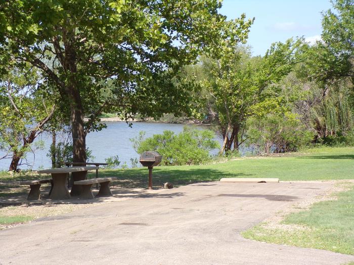 A photo of Site 023 of Loop RCOV at RICHEY COVE with Picnic Table, Electricity Hookup, Fire Pit, Shade, Waterfront, Water Hookup